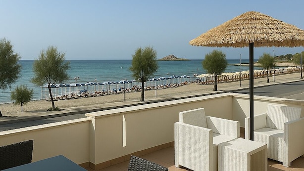 Un balcon avec vue sur la mer, des meubles en osier blancs et un parasol en chaume.