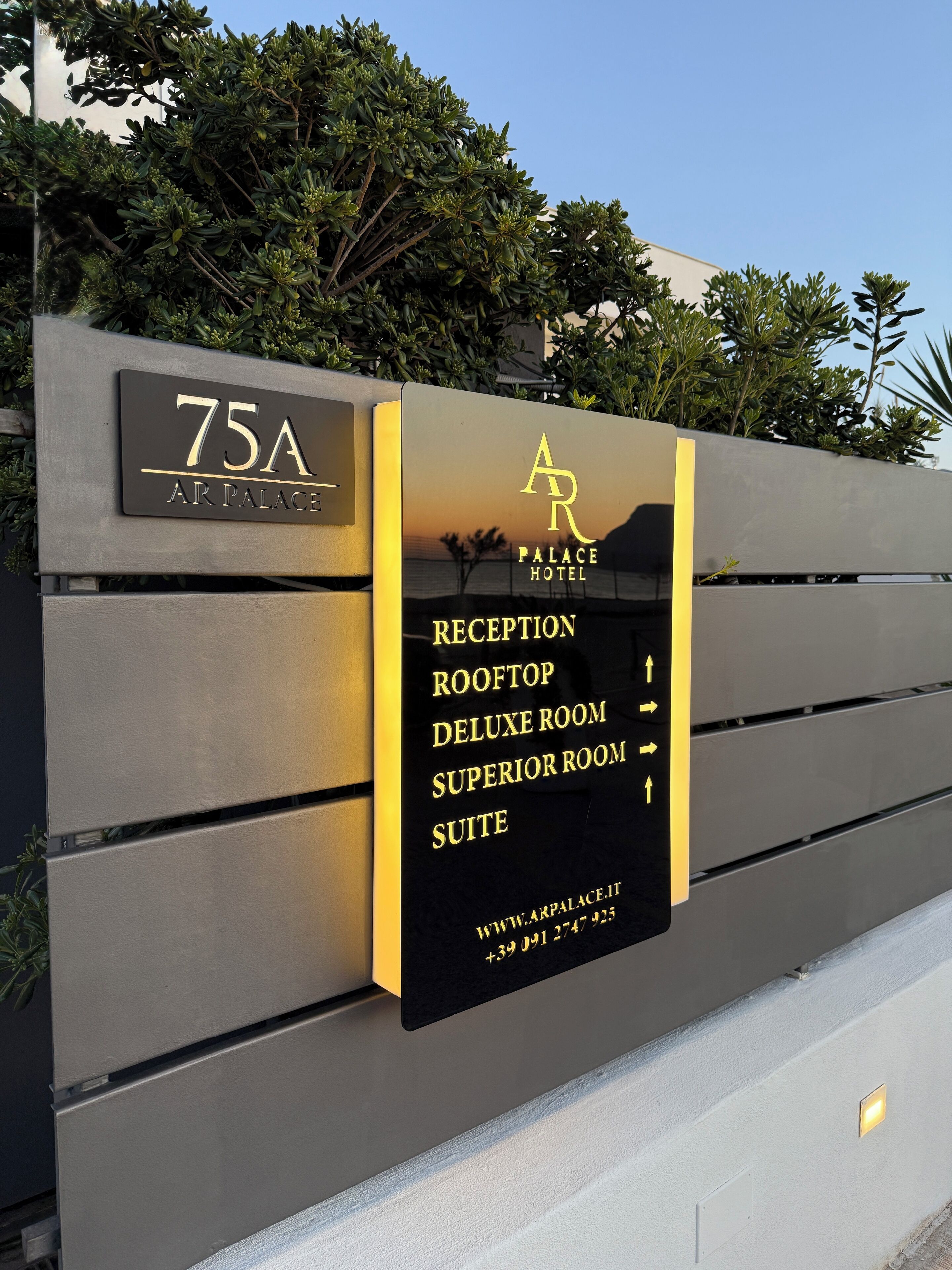 A hotel sign with room types and contact information.