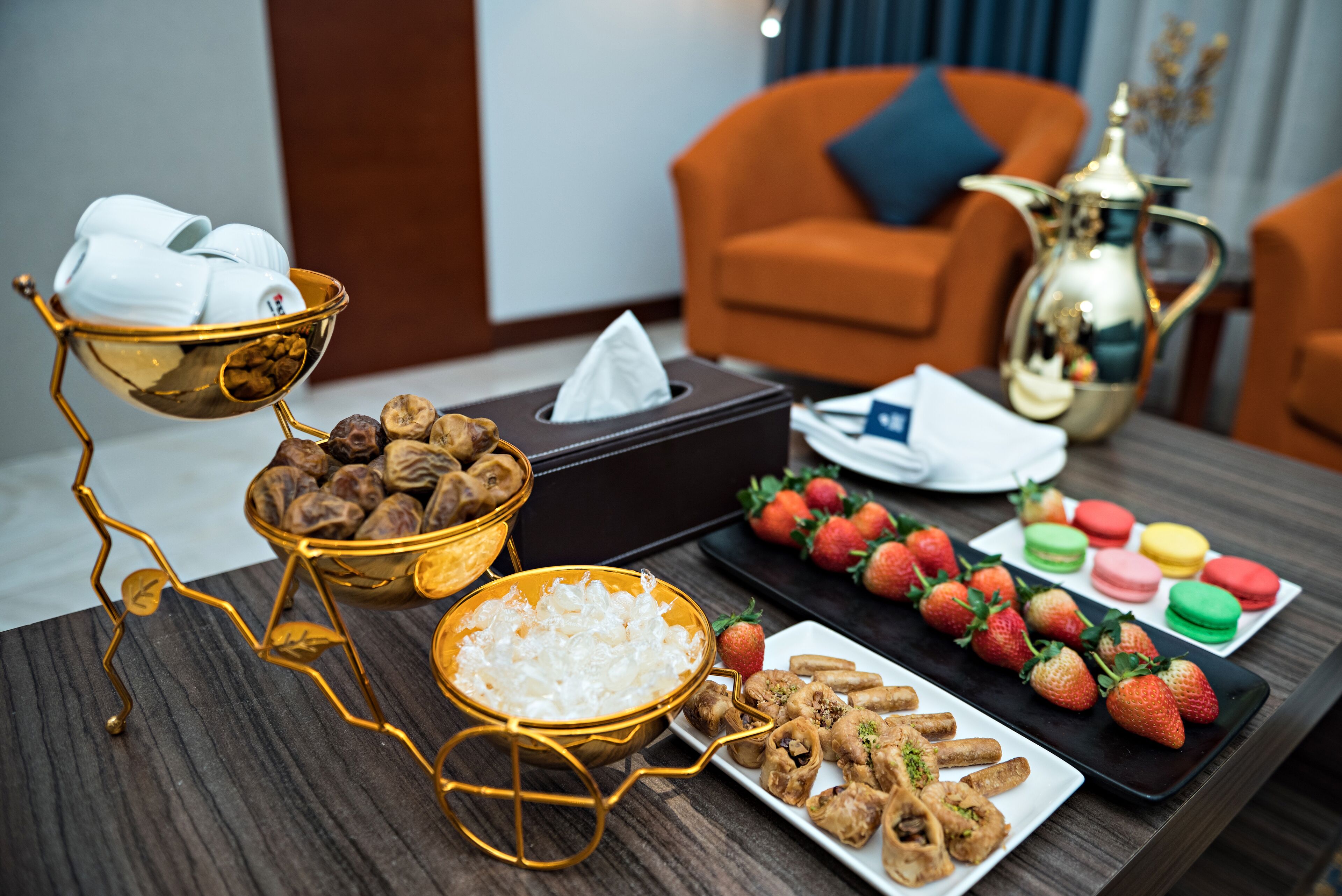 A table with food items, a tissue box, and a decorative pitcher.