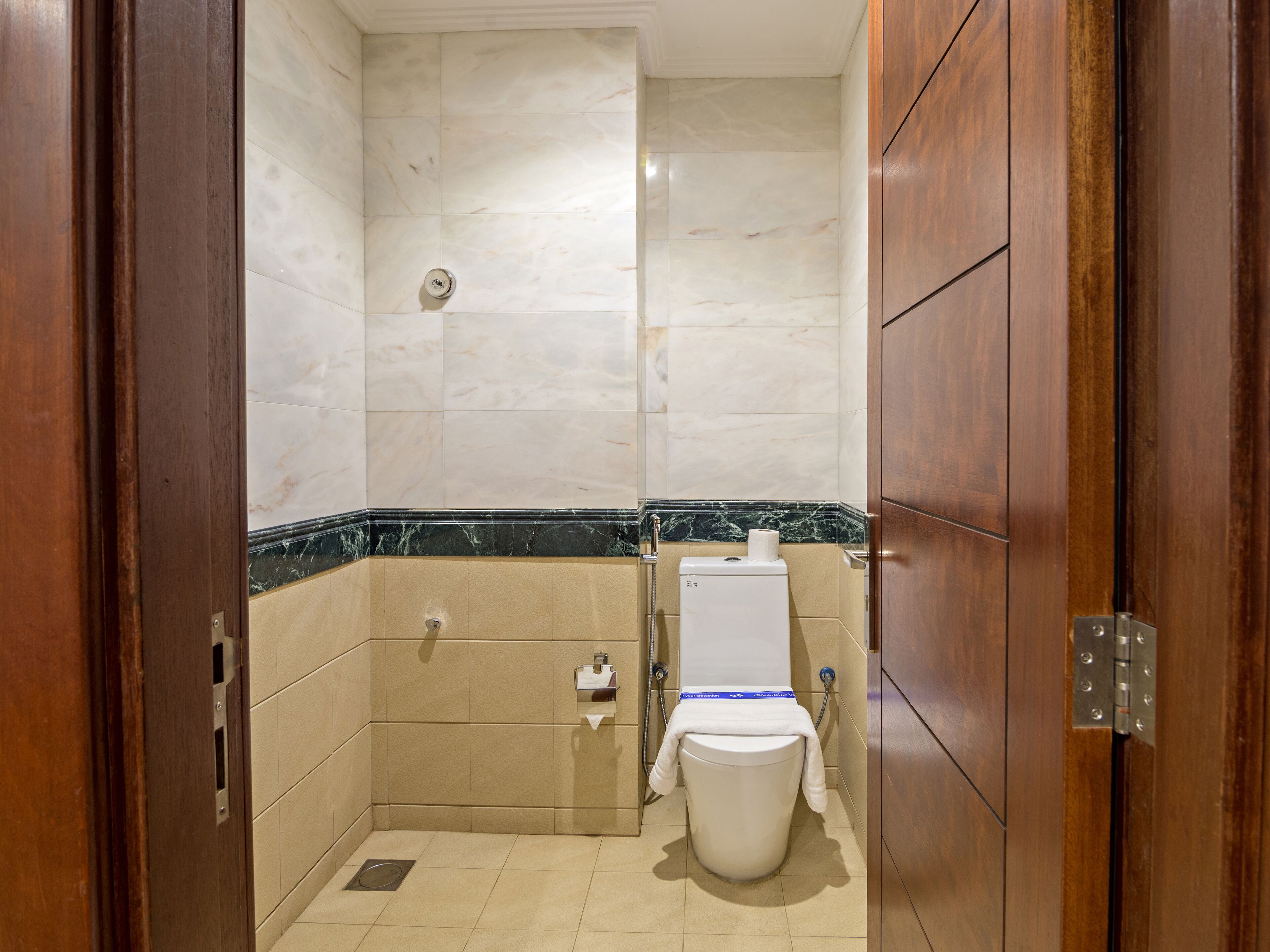A small, clean bathroom with a toilet, a sink, and a shower.