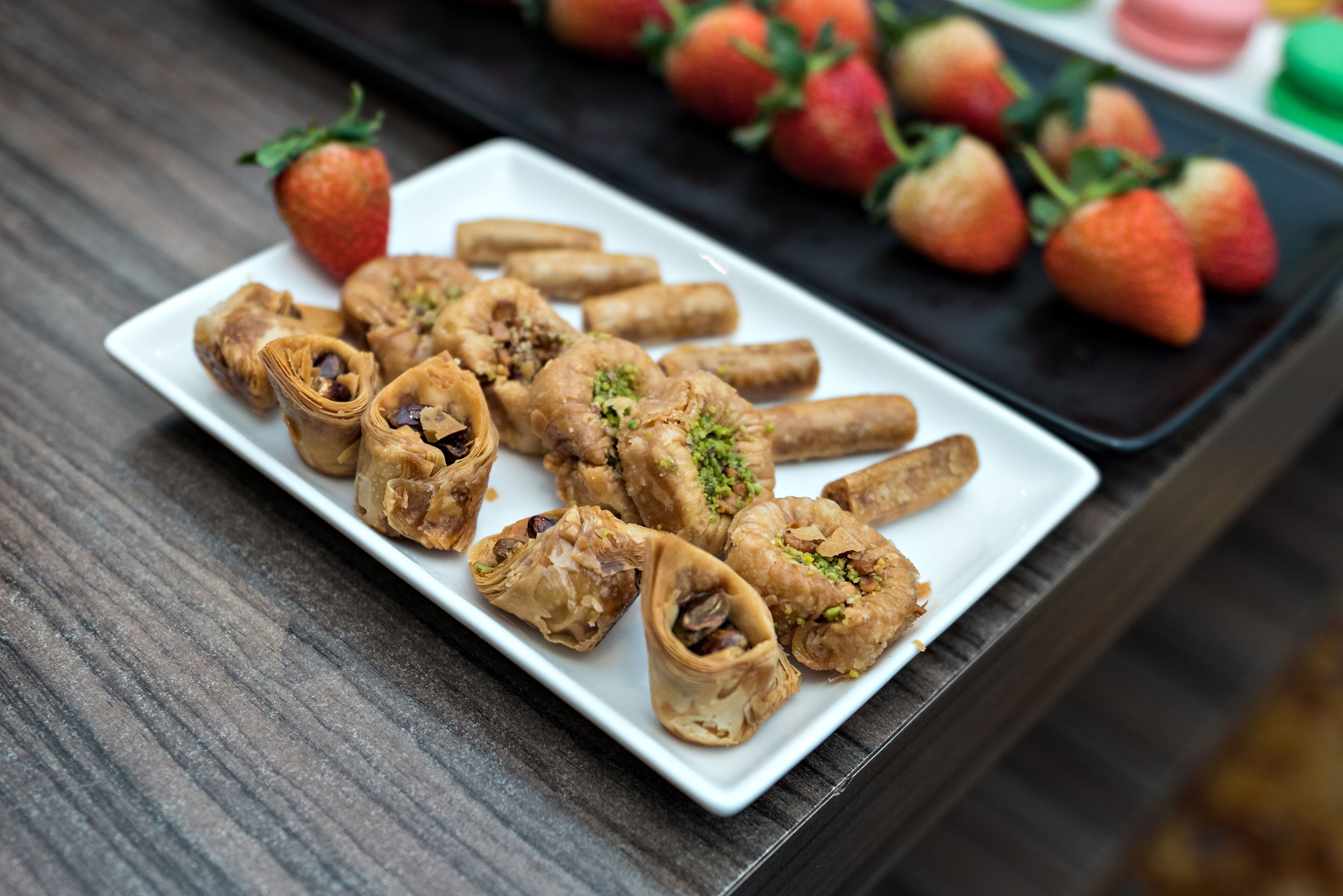 A white rectangular plate with pastries on a wooden table.