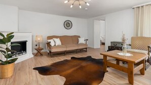 A living room with a sofa, a wooden coffee table, a leather rug, a fireplace, and a ceiling light fixture. - Cozy vacation home Zur Alten Burg/Family reunion/Edersee (Vöhl)