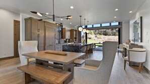 A modern kitchen with dark cabinets, a marble island, and pendant lighting. - Red Ledges cottage, golf, min 90 day stay (Heber City)