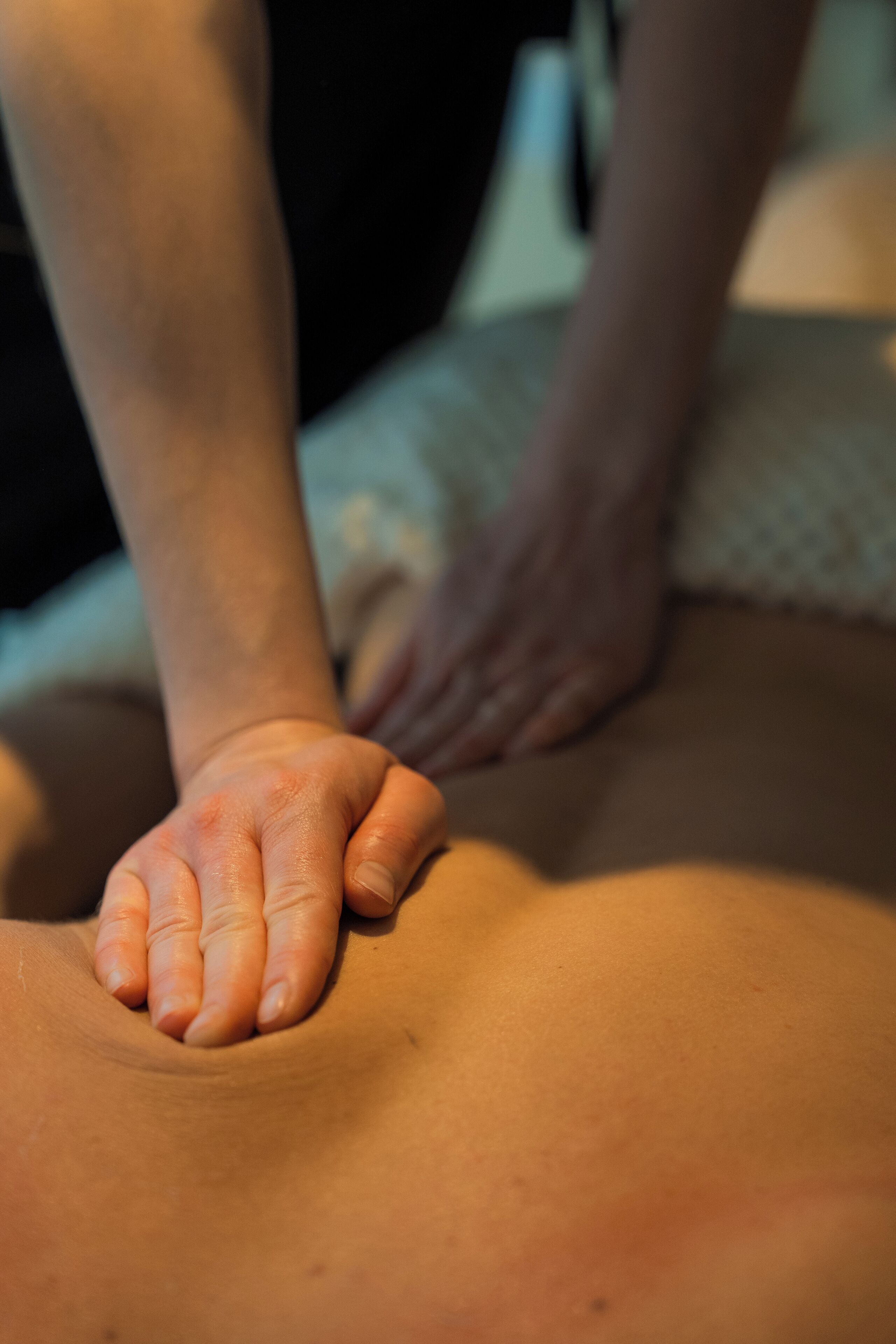 A close-up of a person's hands on a massage table.