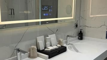 Une salle de bain moderne avec deux lavabos, un grand miroir et un meuble-lavabo avec des articles de toilette.