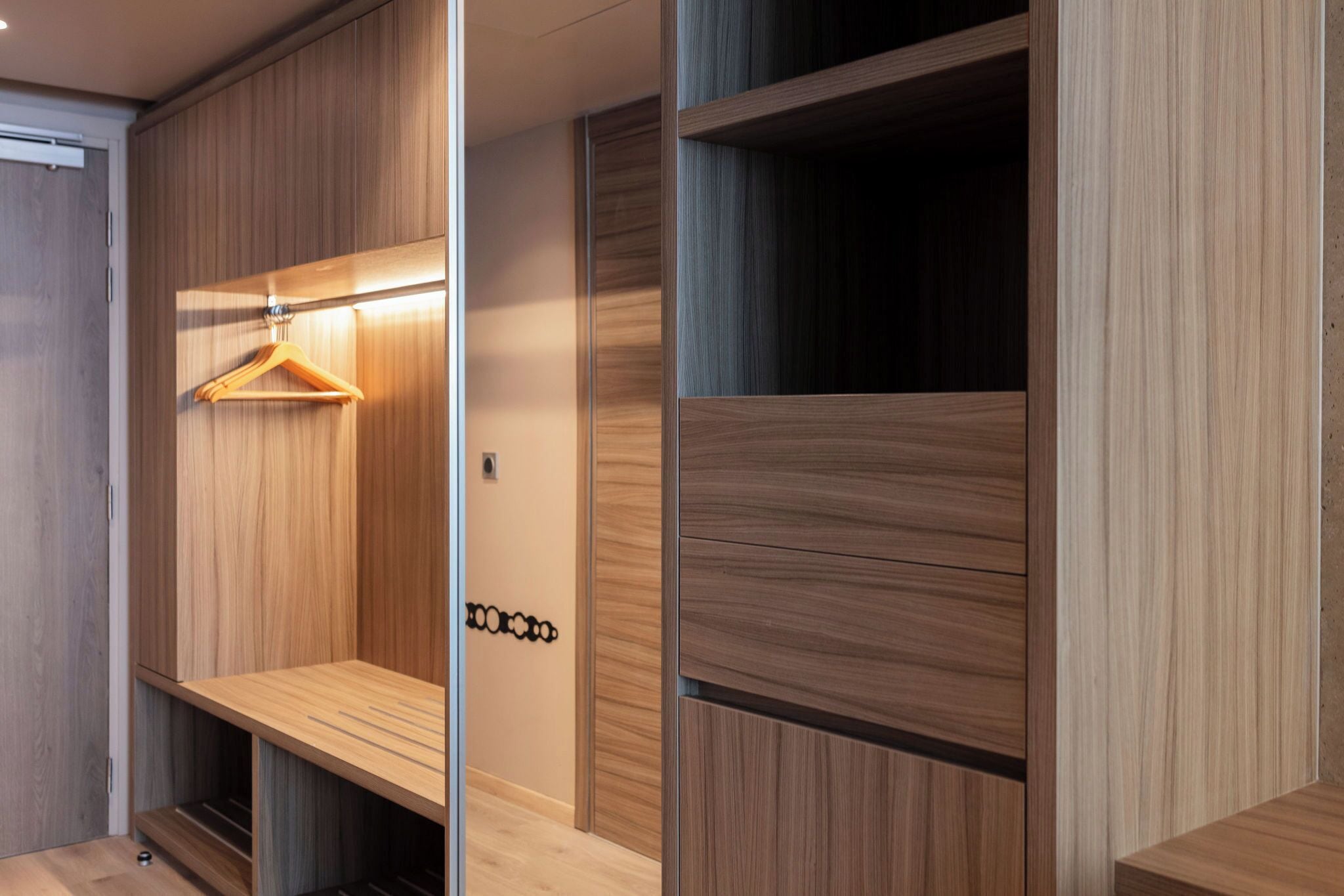 A modern walk-in closet with wooden paneling and a hanging rod.