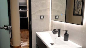 A modern bathroom with a large mirror, a white sink, and a wooden floor. - LView Zeus Temple (Athens)