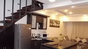 A modern kitchen with a built-in island, a refrigerator, and a microwave. - Sea View Duplex Villa Hurghada  (Red Sea Governorate)