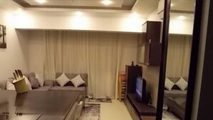 A modern living room with a sofa, a coffee table, a flat-screen TV, and a small table with a lamp. - Sea View Duplex Villa Hurghada  (Red Sea Governorate)