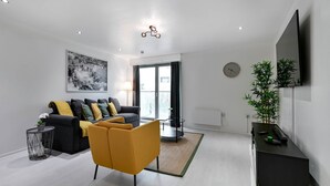 Uma sala de estar moderna com sofá, poltrona e mesa de jantar.