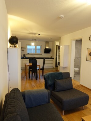 Ein modernes Wohnzimmer mit einer Couch und einem Essbereich mit Tisch und Stühlen.