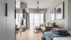 A modern bedroom with a bed, a sofa, a coffee table, and a TV. - MARGI Smart Apartment  (Szczecin)
