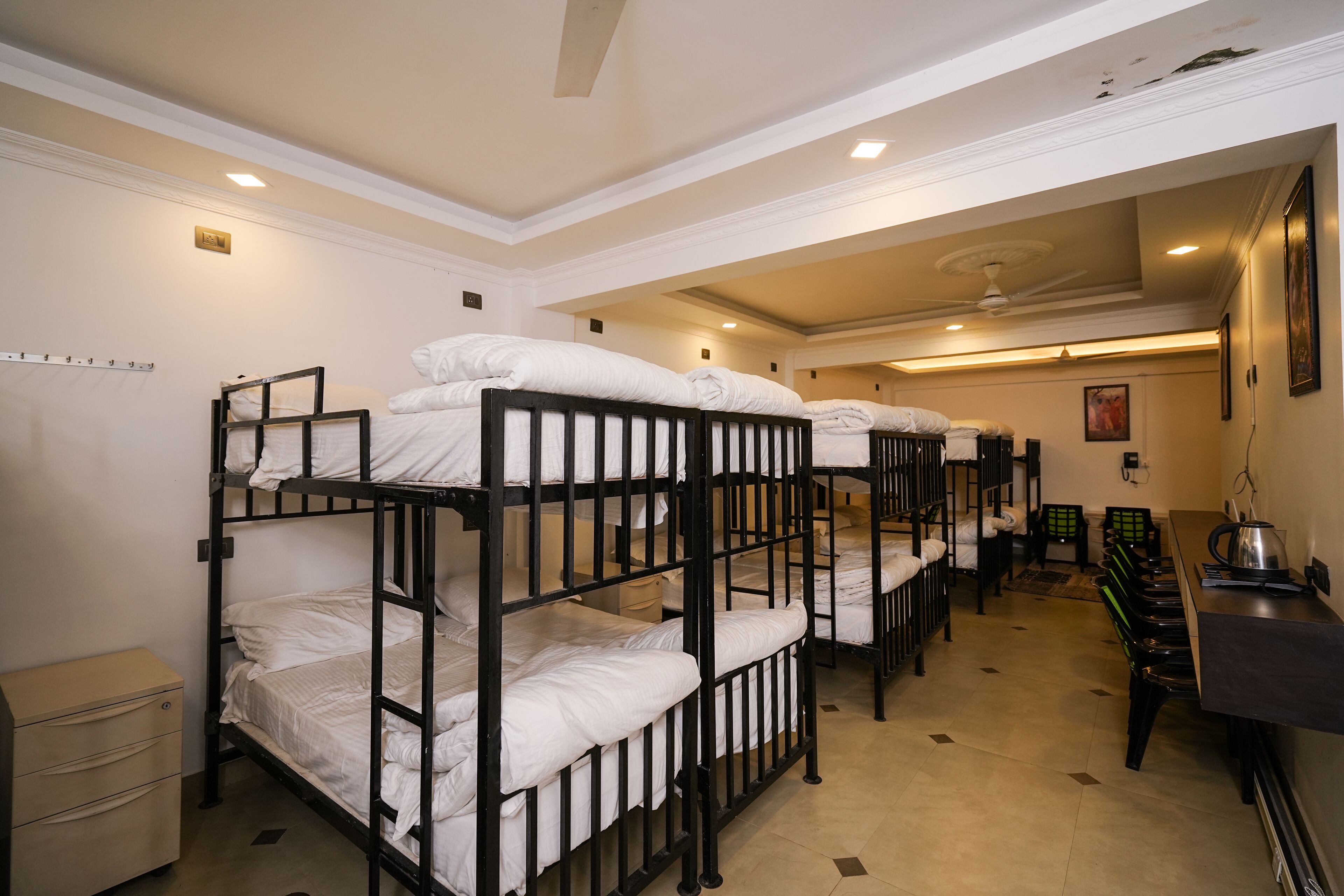 Een slaapkamer met stapelbedden, een bureau en een stoel.