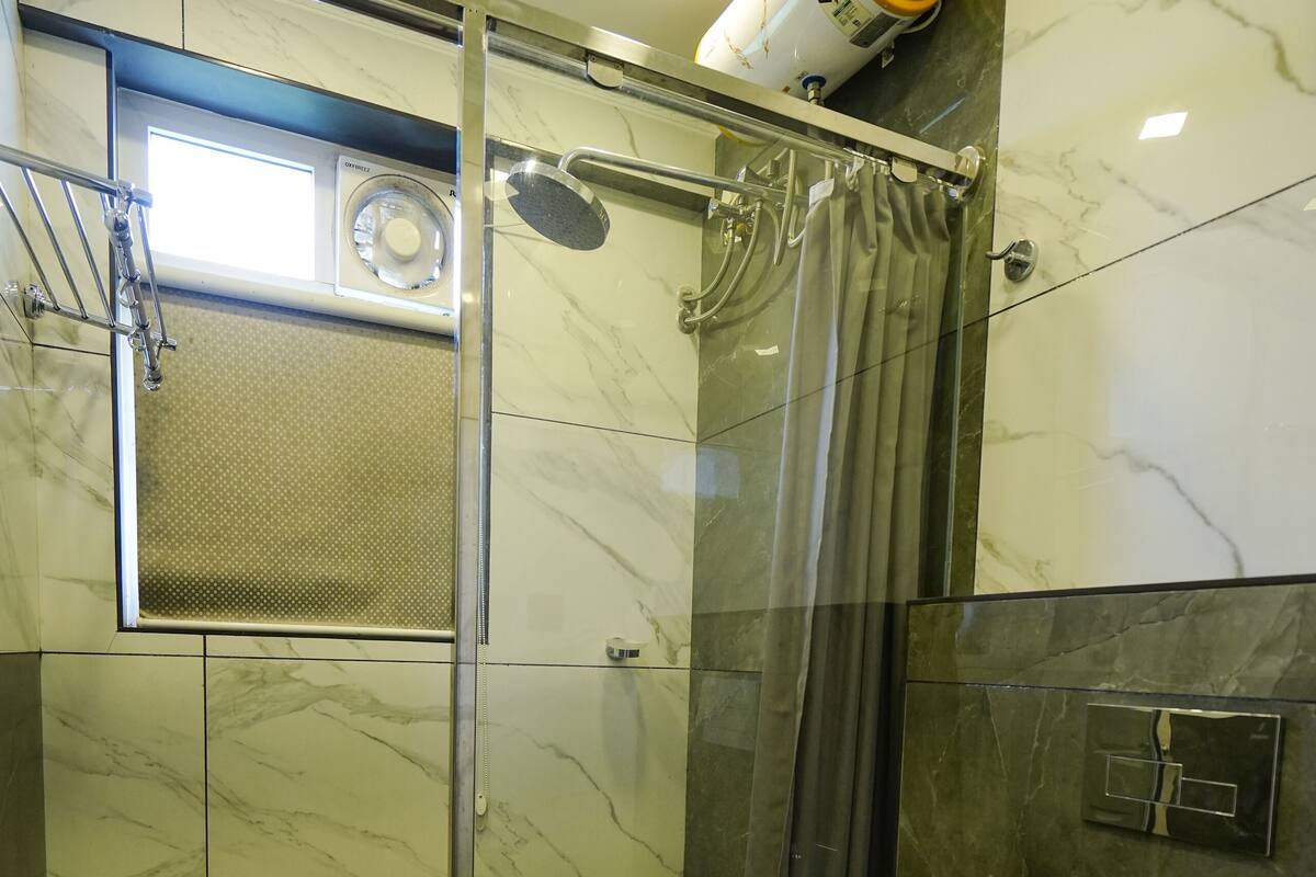 A modern bathroom with a glass-enclosed shower, a toilet, and a sink.