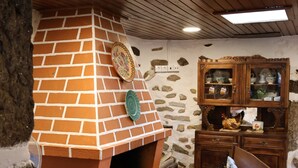 Una cocina rústica con un horno de ladrillo, armarios de madera y una pared de piedra.