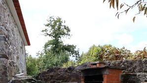 Un sendero de piedra que conduce a una construcción de ladrillo con una chimenea.