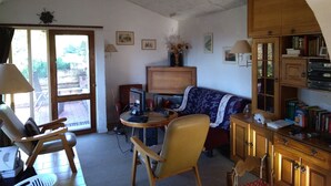 A cozy living room with a wooden cabinet, a sofa, a table, and a chair. - Detached Holiday Home on Olive Grove with Beautiful Sea View (Liguria)