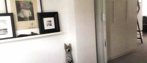 A hotel room with a bed, a framed picture on the wall, and a wardrobe.