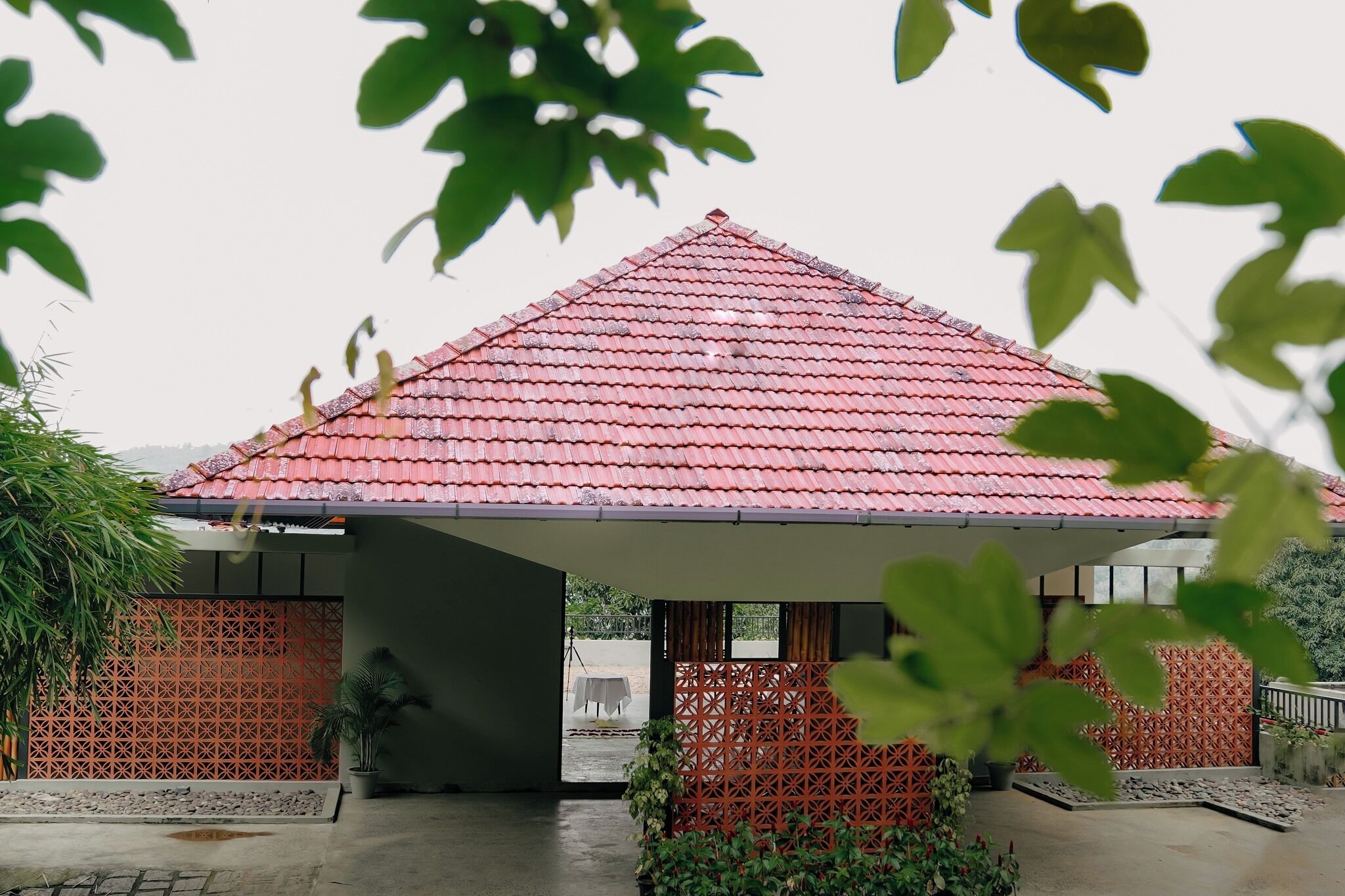 A building with a red tiled roof, a covered entrance, and a decorative fence.