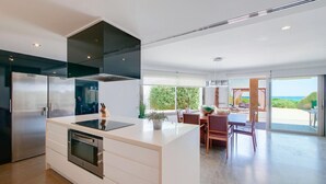 Cocina moderna con una isla central, electrodomésticos de acero inoxidable y vistas al exterior.