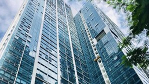 Un grattacielo moderno e slanciato, con finestre a vetro riflettente e una facciata geometrica.