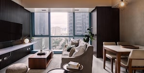 Enjoy the city view from this stylish living room with a flat-screen TV, comfortable sofa, and dining area.