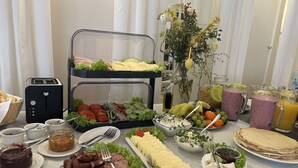 Una mesa de buffet con diversas opciones de comida, como carnes, quesos, frutas y bebidas.