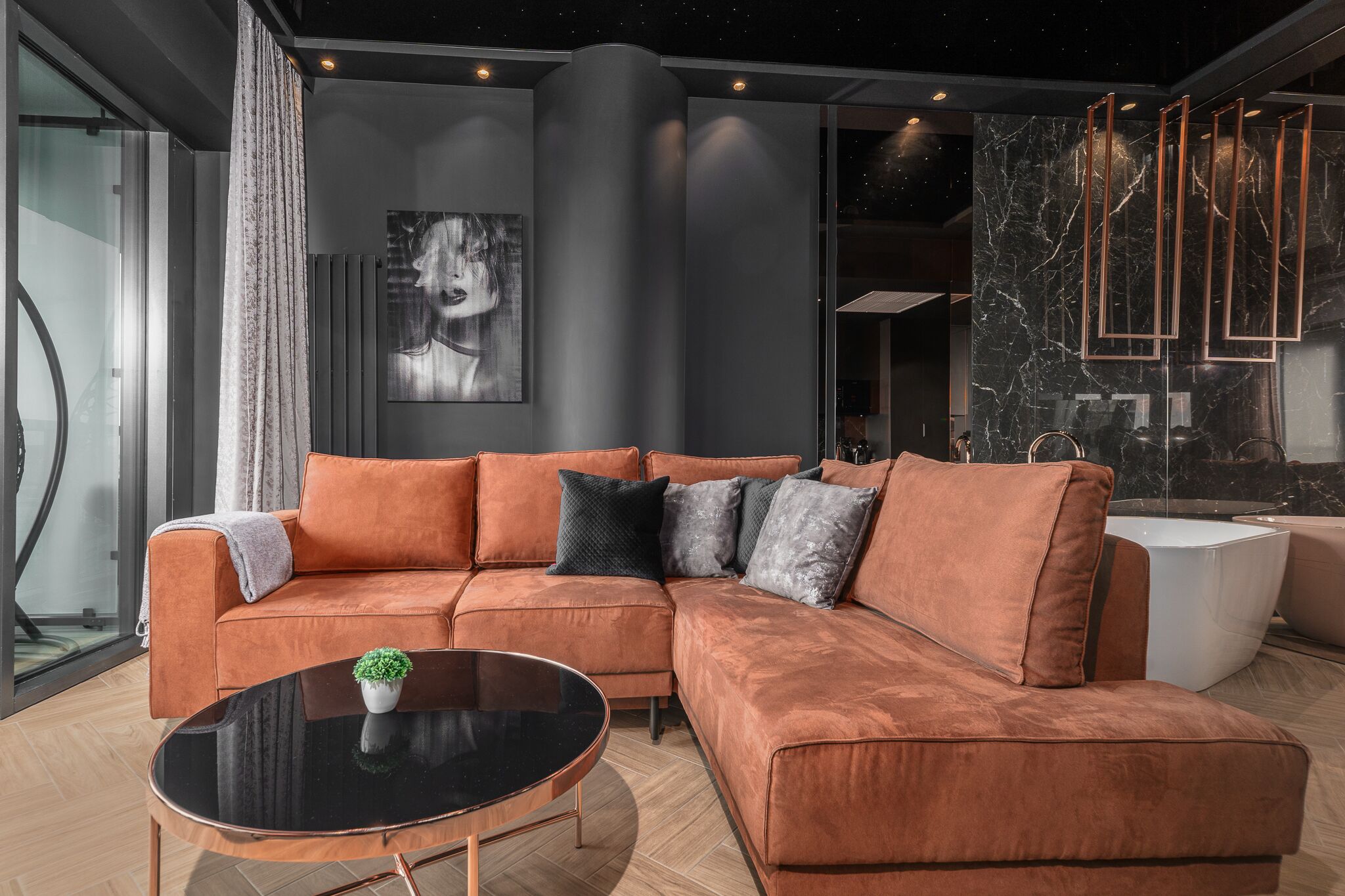 A modern living room with a sectional sofa, a round coffee table, and a large painting on the wall.