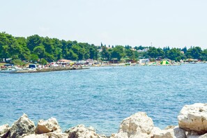 Eine Küstenstadt mit felsiger Küstenlinie, Booten und Gebäuden am Wasser.