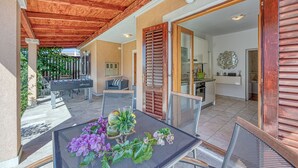 A covered patio area with a table and chairs, a foosball table, and a view of the house interior. - Coastal Paradise Villa With Pool (Sveti Filip i Jakov)