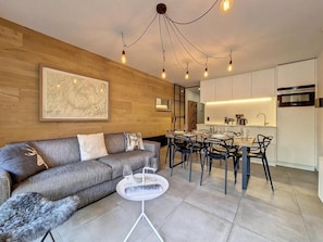 A modern living room with a grey sofa, a coffee table, and a dining area with chairs and a table. - 200m from resort center, 1st floor, balcony, tv, ski locker, 40m², Saint Martin de Belleville (Saint-Martin-de-Belleville)