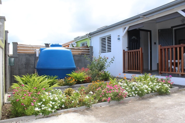 Façade et jardin fleuri. Réservoir tampon pour éviter les coupures d'eau.