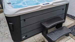 A hot tub with a control panel, a step for access, and a label on the side. - Traumhafte Wohnung Über Zwei Ebenen mit Infrarotkabine, Balkon und Terrasse (Göhren-Lebbin)