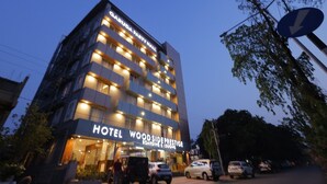 A multi-story hotel with a sign for "Hotel Wood Side Prestige" and "Garuda Party Hall" on the facade. - Hotel Woodside Prestige Tirupati (Tirupati)