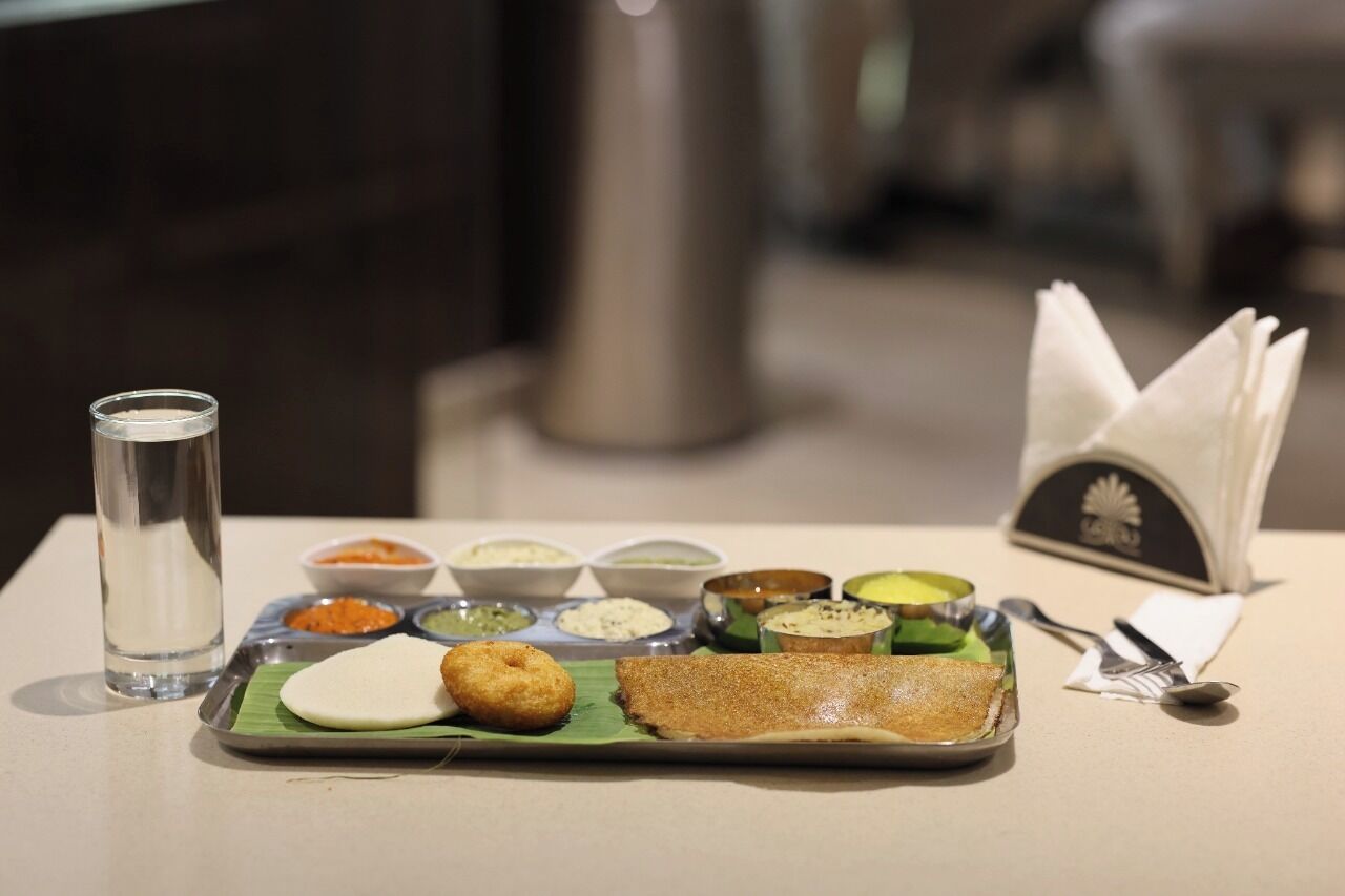 A meal with a plate, a glass of water, and a napkin on a table.