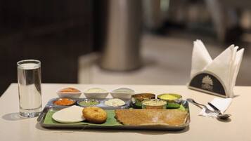 A meal with a plate, a glass of water, and a napkin on a table.