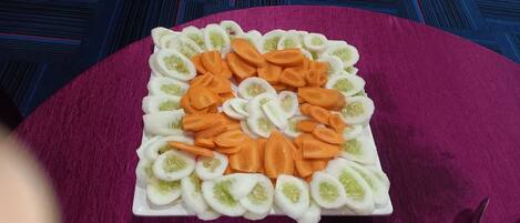 Un plato cuadrado con verduras cortadas dispuestas en forma de corazón.