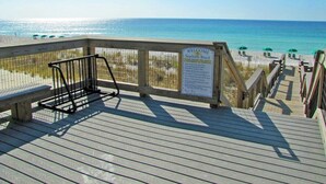 A wooden boardwalk leading to a beach with a 'Welcome' sign, benches, and umbrellas. - Paradise Reef Private Pool! Walk to the Beach! Sleeps 10! Jacuzzi! Pet Friendly! (Miramar Beach)