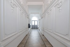 Stunning hallway with polished floors and classical moldings leads to a grand arched entrance.