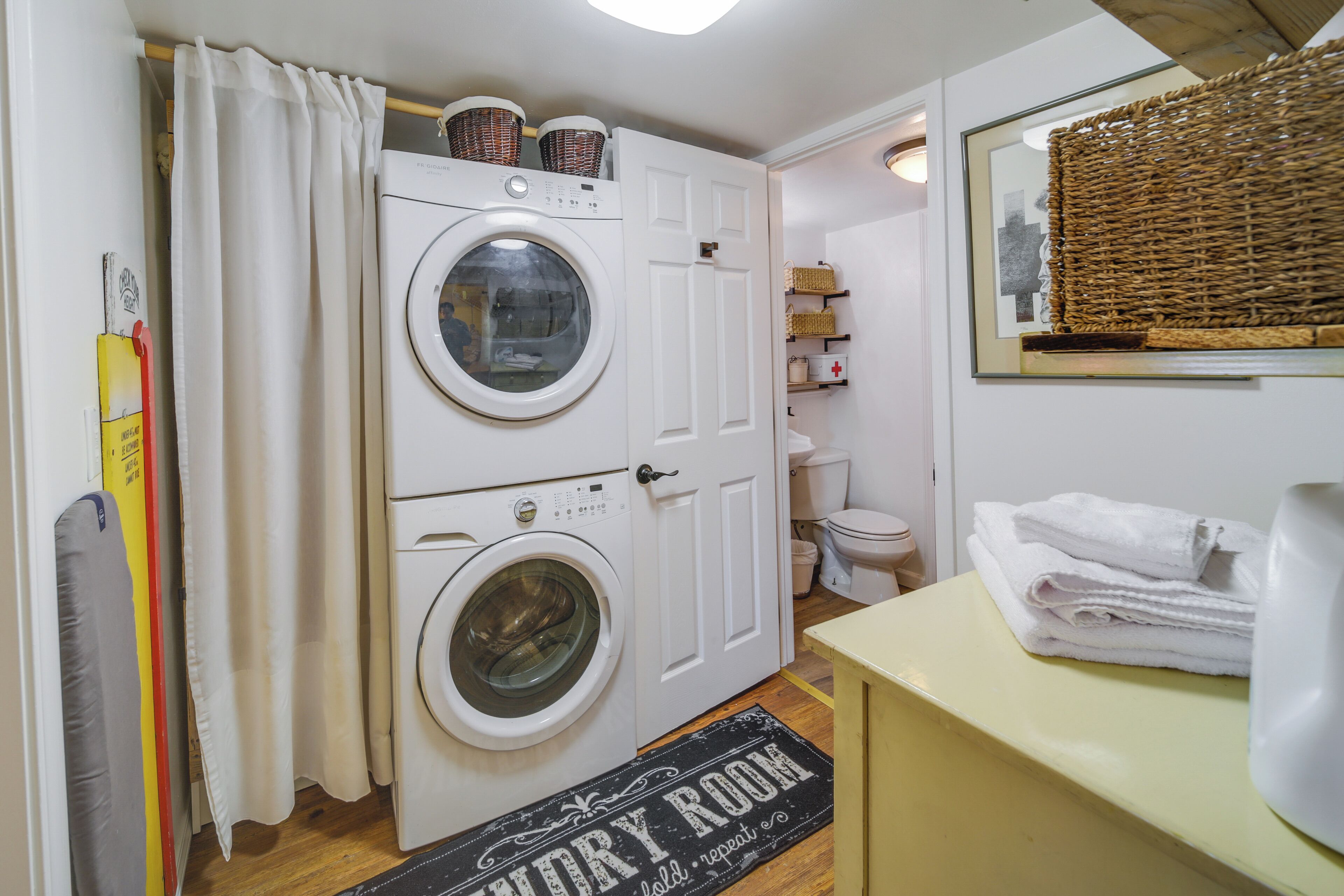 Een wasserij met een wasmachine, een droogrek en een bord waarop staat 'Wasserij herhalen'.