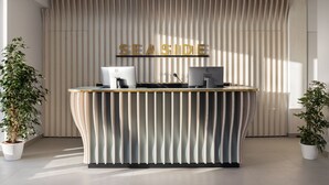 A reception desk with a modern design, featuring a wooden top and a vertical striped backdrop. - Seaside Hotel (Capo d'Orlando)
