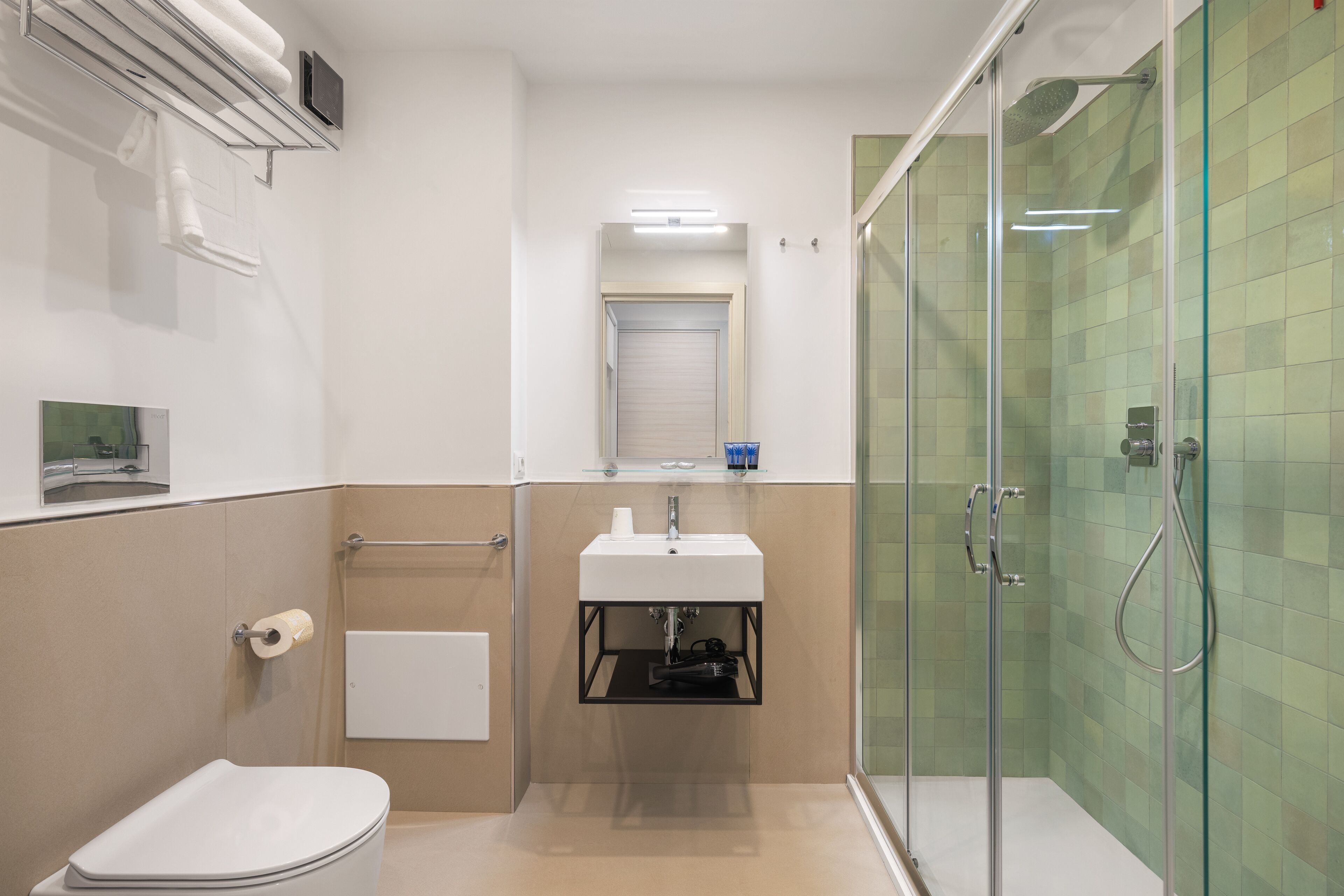 A modern bathroom with a toilet, sink, and glass-enclosed shower.