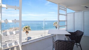 A balcony with a white table and chairs, overlooking a beach and the sea. - Seaside Hotel (Capo d'Orlando)