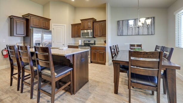 Una cocina moderna con armarios de madera, electrodomésticos de acero inoxidable y una isla central con asientos.