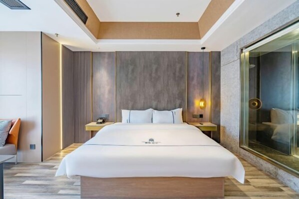Una habitación de hotel moderna con una cama grande, una pared de vidrio y un techo de madera.