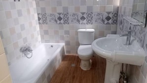 Ein Badezimmer mit Badewanne, Toilette und Waschbecken.