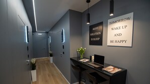 A modern reception area with a desk, bar stools, and a motivational quote on the wall.
