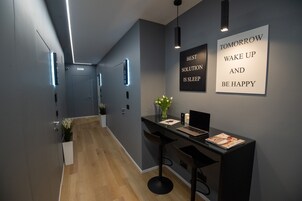 Una moderna area reception con scrivania, sgabelli da bar e una citazione motivazionale sulla parete.
