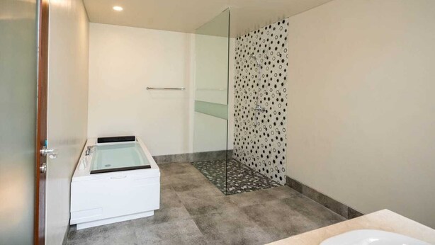 A modern bathroom with a glass shower enclosure, a bathtub, and a toilet. - Shankara Munduk Bali (Munduk)