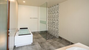 Een moderne badkamer met een douchecabine, een bad en een wastafelmeubel met een wastafel.